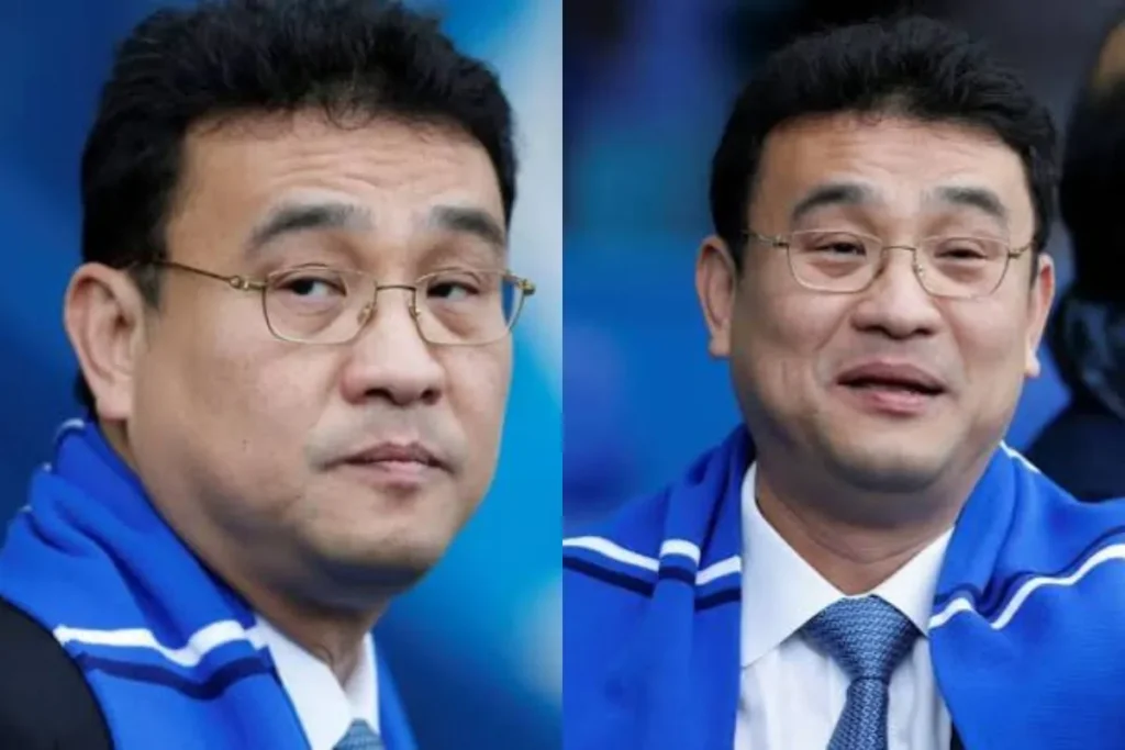Dejphon Chansiri Net Worth illustrated with side-by-side portraits of Dejphon Chansiri wearing a blue scarf, glasses, and a business suit. Select 78 more words to run Humanizer.